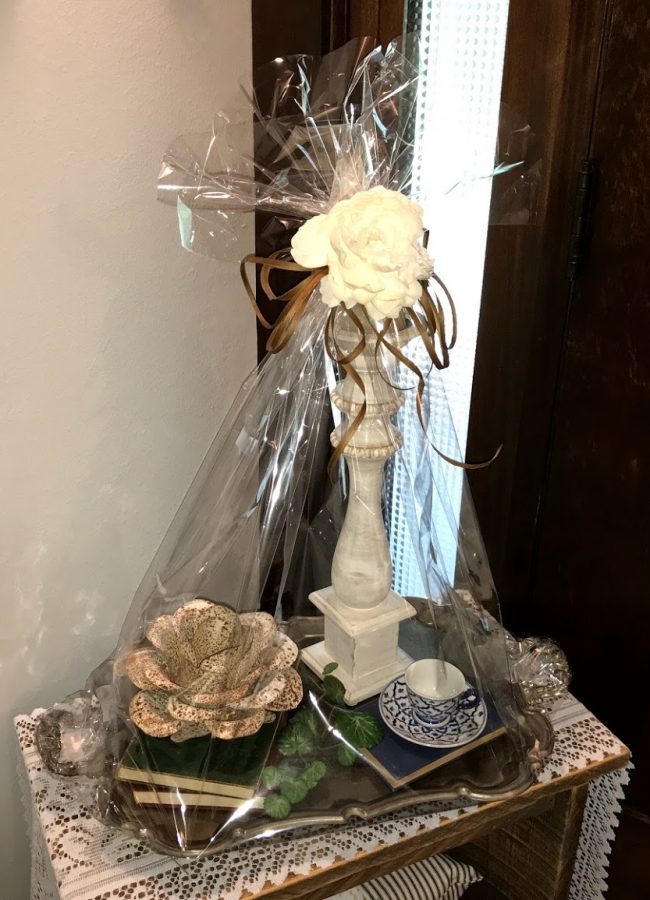 Vintage tray, books, tea cup/saucer, with metal flower, candlestick, and greenery